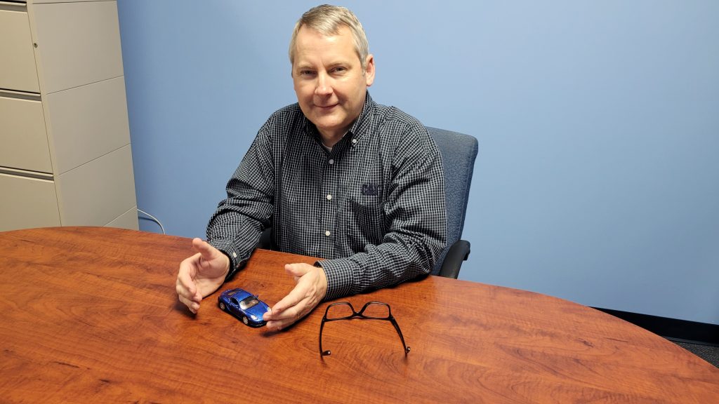 Insurance Agent covering a small toy car with his hands