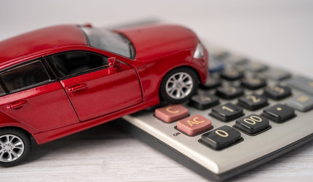 a toy car standing on a calculator